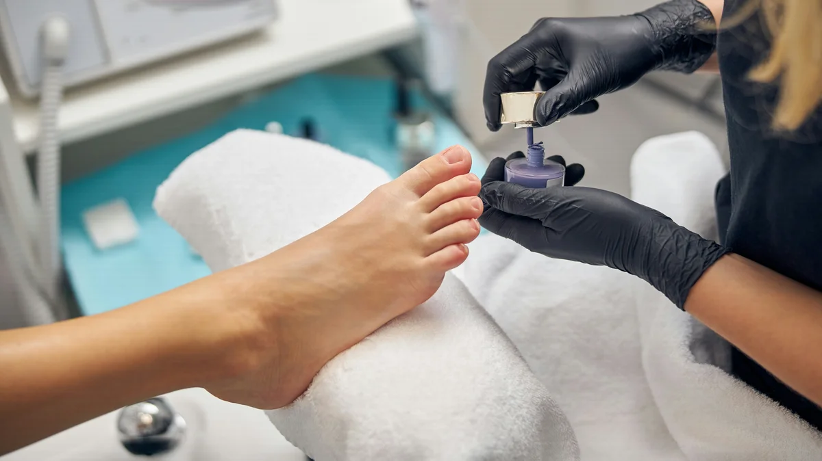 Primo piano di una manicurista che fa il pedicure a una cliente in salone